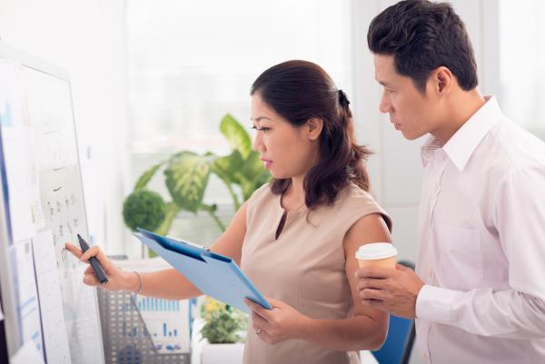 Two people stand in front of a whiteboard brainstorming education-technology-solutions